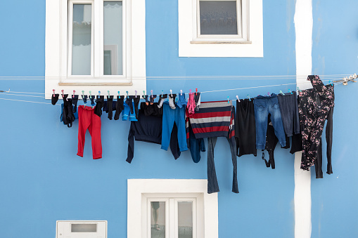 clothline with fresh washed clothes hanging at the facade of a house