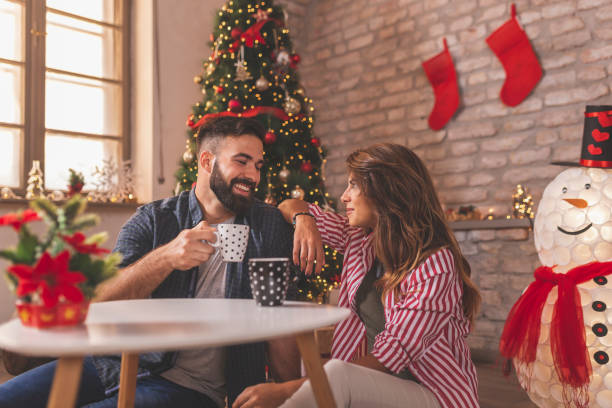 paar trinkt kaffee am weihnachtsmorgen - communication discussion coffee christmas stock-fotos und bilder