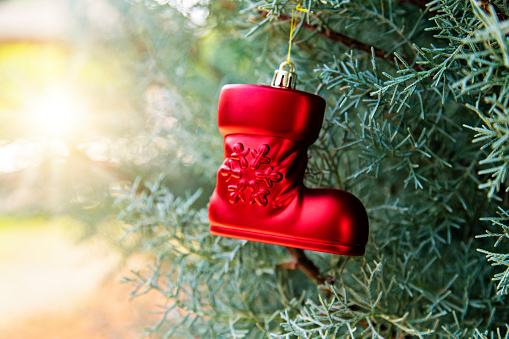 Red Boot Shape Christmas Bauble hanging on a tree.