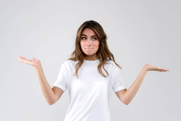 istock Woman standing on a white background throwing up her hands in doubt. Human emotions 1273172509
