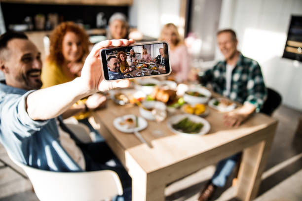 istock Smiling man holding his mobile phone to make photo 1273172774