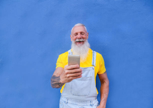 istock Elderly hipster man with mobile phone enjoy technology - Trendy senior man laughing 1273193075