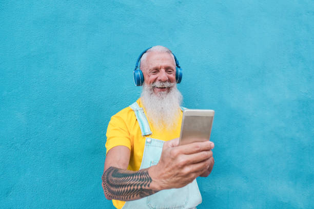 istock Happy senior man looking at his smartphone - Elderly hipster laughing and enjoy technology 1273193086