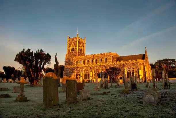 Photo of Early morning sun lights up the church in Stratford St Mary in Suffolk, UK