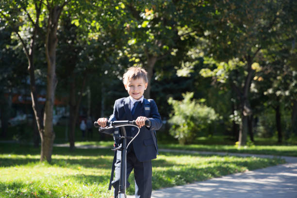 istock Schoolboy with backpack goes on a scooter to school 1273194388