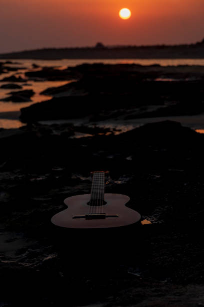 istock The guitar stands on the ground at sunset 1273194625