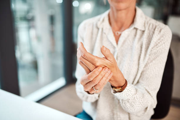 Dealing with hand pain and stiffness Closeup shot of an unrecognisable businesswoman experiencing discomfort in her hand while working in an office carpal tunnel syndrome photos stock pictures, royalty-free photos & images
