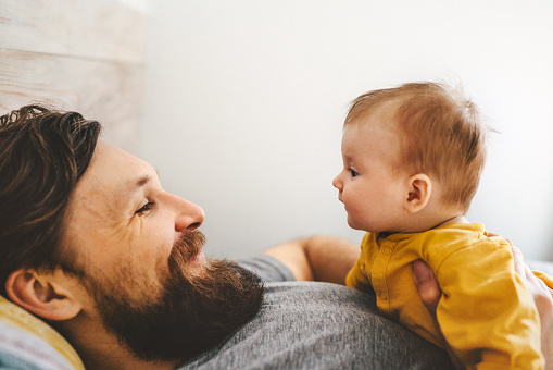 Father and baby daughter playing together family home lifestyle dad and child parenthood love emotions concept