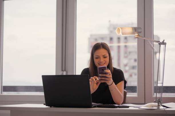 istock one young woman, using her smart-phone, in apartment. 1273197025