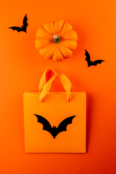 istock Orange paper bag, black bats and pumpkin 1273198347