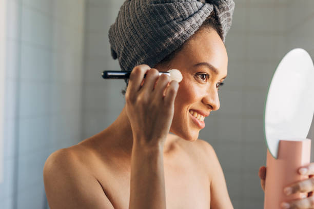 istock Beutiful African American Woman Putting on Make Up after Having a Shower 1273200126