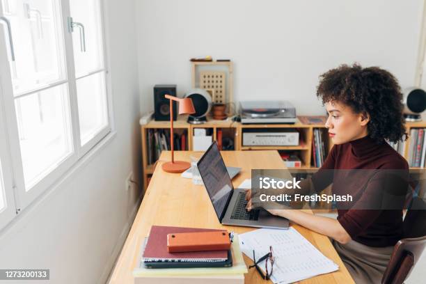 At The Home Office African American Woman Sitting At Her Desk And Working On Her Laptop Pc Stock Photo - Download Image Now