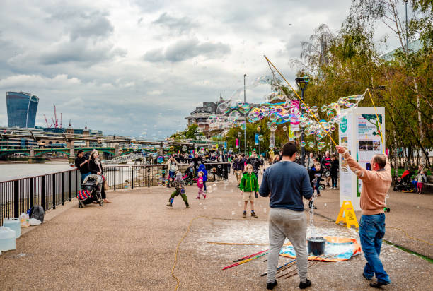 jouer avec des bulles de savon, sur southbank, londres. - soap sud water froth bubble photos et images de collection