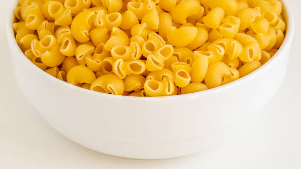 istock Raw dry uncooked Mini pipe rigate pasta spaghetti noodle on white bowl wooden background for basil tomato pesto sauce Homemade Italian food organic whole wheat vegan spaghetti for a healthy meal 1273205003