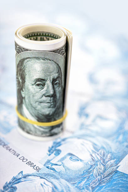 istock one hundred dollar bill over one hundred dollar banknotes, point focus. Concept of devaluation of the Brazilian currency and high dollar 1273205824