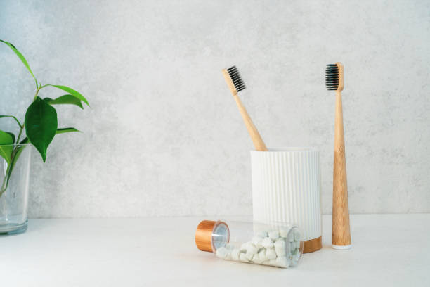istock Zero waste bathroom items. Bamboo toothbrushes in recycling material holder, natural mouthwashing tabs and fresh green plants in glass. Oral care essentials. Eco-friendly home. Minimalism. Copy space. 1273206235