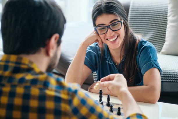 Young Man And Woman Having Fun And Playing Chess