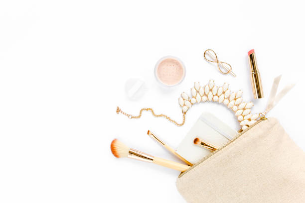 istock Beige cosmetic bag, makeup brushes, cosmetics, golden accessories on white background. Flat composition. magazines, social media. Top view. Flat lay 1273210179