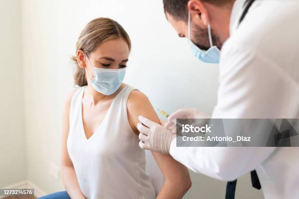 Doctor Applying A Vaccine On A Womans Arm Stock Photo - Download Image Now - Vaccination, Coronavirus, Women