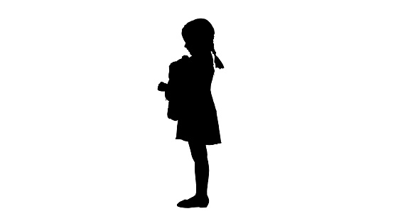 Wide shot. Front view. Silhouette Little girl in polka dot dress hugging teddy bear really tight smiling at camera. Professional shot in 4K resolution. 060. You can use it e.g. in your medical, commercial video, business, presentation, broadcast