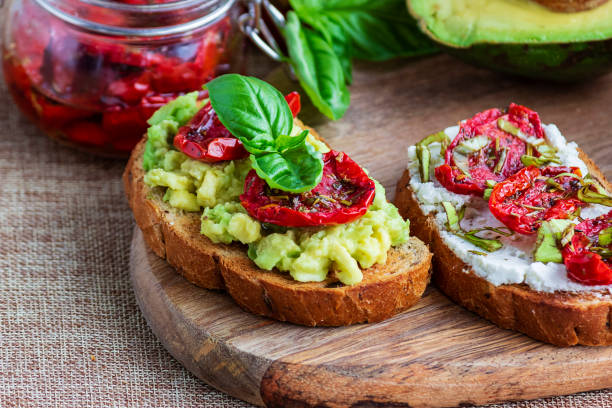 istock Sandwich with sun-dried tomatoes, avocado, basil, curd cheese on croutons. Vegetarian breakfast or snack 1273222737