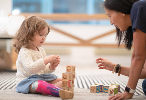istock Girl with prosthetic leg sees support worker/ physician 1273222979