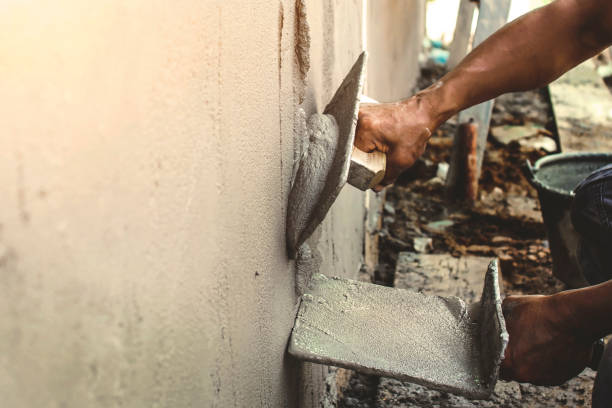 istock Close-up of workers using plaster trowel to plaster the walls for house construction, working ideas and residential construction. 1273226200