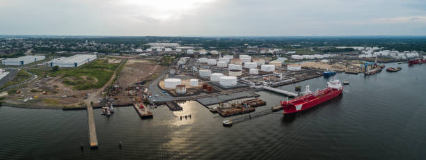 istock Drone elevated view on the industrial cargo ship unloading at the petroleum terminal in New Jersey, on the Arthur Kill tidal strait at the border with New York State. High resolution aerial stitched panorama. 1273234241