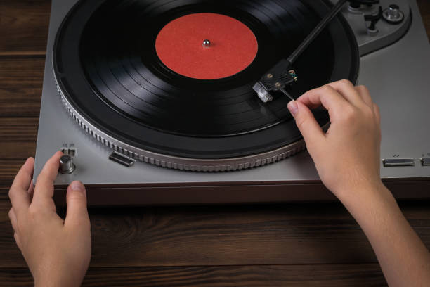 istock Hands turn on music playback on vinyl disc players. 1273235126
