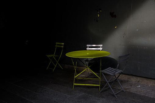 Empty Table with chairs outdoors with dramatic light in New York, NY, United States