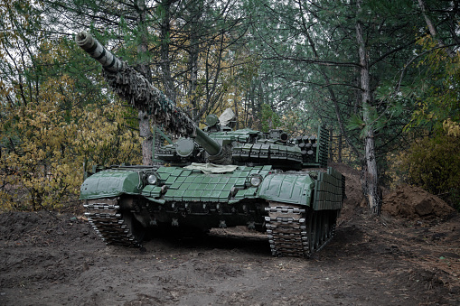panzer T-64 en servicio de combate en un bosque de coníferas photo