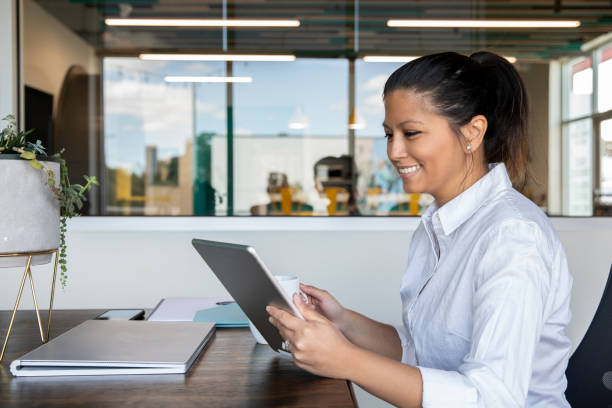 istock Happy professional woman uses digital tablet while sitting at desk in her office 1273236710