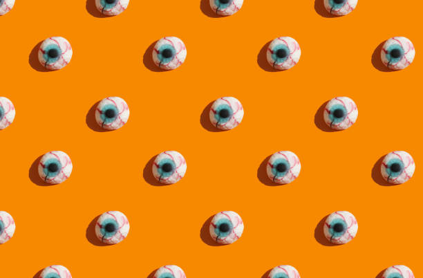 istock sunlight pattern made with marmalade in form of monster eyes on bright orange background. Funny holiday flat lay concept. 1273237705