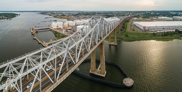Aerial view on the oil storage tanks at a petroleum terminal over the Outerbridge Crossing bridge, in New Jersey at the border with the New York State, USA.