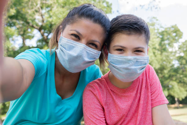 Mother and son smile under their masks for selfie
