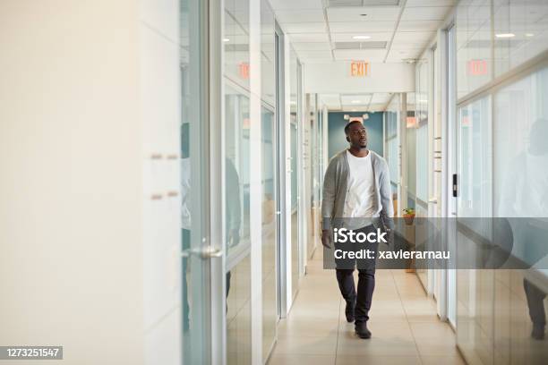 Relaxed Black Freelancer Walking In Miami Coworking Office Stock Photo - Download Image Now