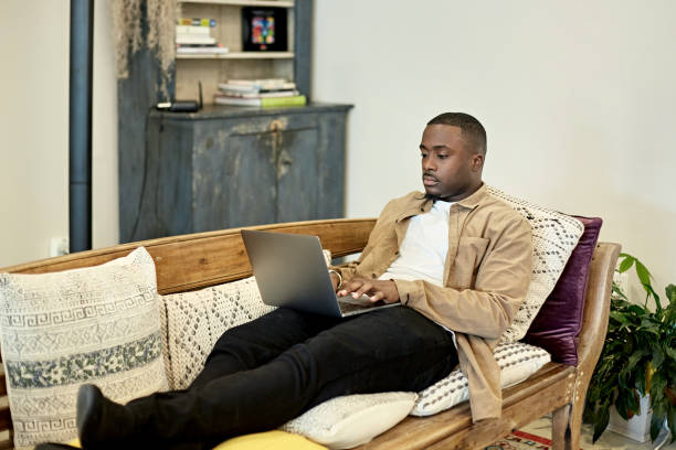 istock Black Freelancer Using Laptop on Sofa in Coworking Office 1273251552