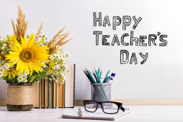 букет цветов и тетради с очками на столе. надпись счастливого дня учителя. - с днем учителя стоковые фото и изображения