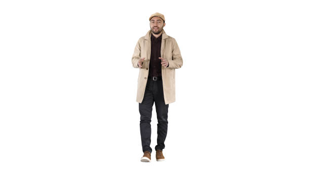 istock Young man wearing trench coat talking to camera on white backgro 1273253271