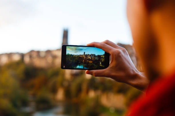 istock Traveler with backpack taking photo by mobile phone. back 1273253376