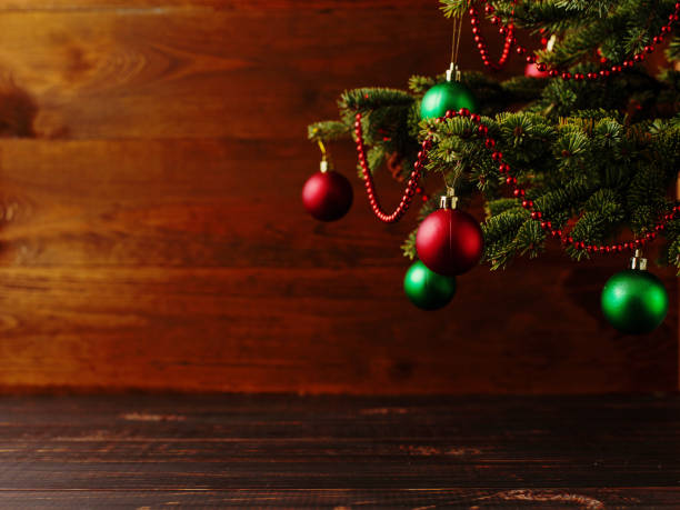 el árbol de navidad, las bolas vestidas, se para sobre una mesa de madera. copiar espacio. - debajo de fotografías e imágenes de stock