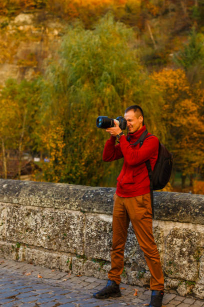 istock Traveler with backpack taking photo by mobile phone. back 1273253639