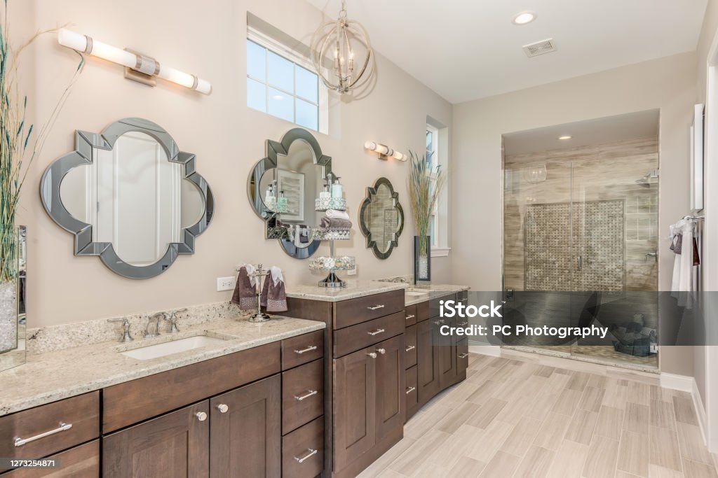 Countertop space galore in elegant bathroom Three mirrors with a high awning window in master bathroom Bathroom Stock Photo