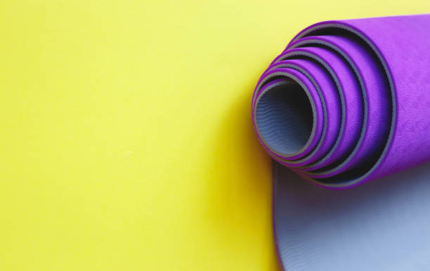 istock Bright purple yoga mat on a yellow background 1273255635