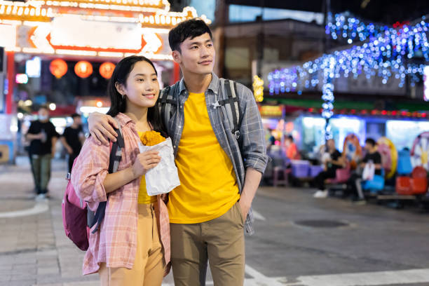 istock couple backpackers in night market 1273255850