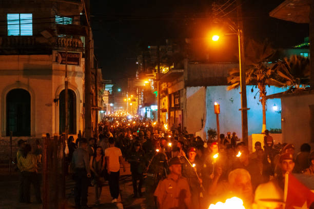 Santa Clara, Cuba - January 27 2019: Thousands of people marching down the street holding in their hands torches lit at night