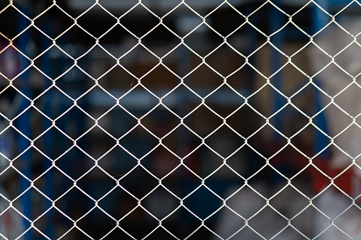 Metal wire mesh fence of chemical storage room (as blurred background) in the industrial factory.