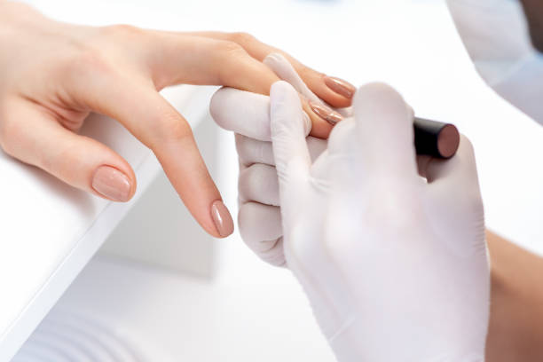 istock Manicure master applying beige nail polish 1273259377
