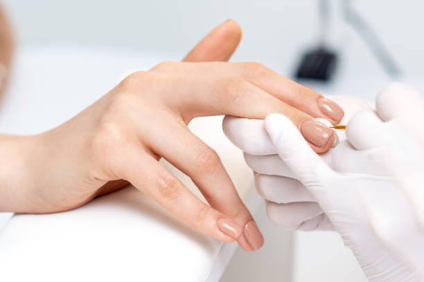 istock Manicure master applying beige nail polish 1273259397