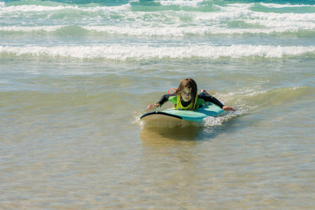 istock cute little girl surfing the waves 1273262454